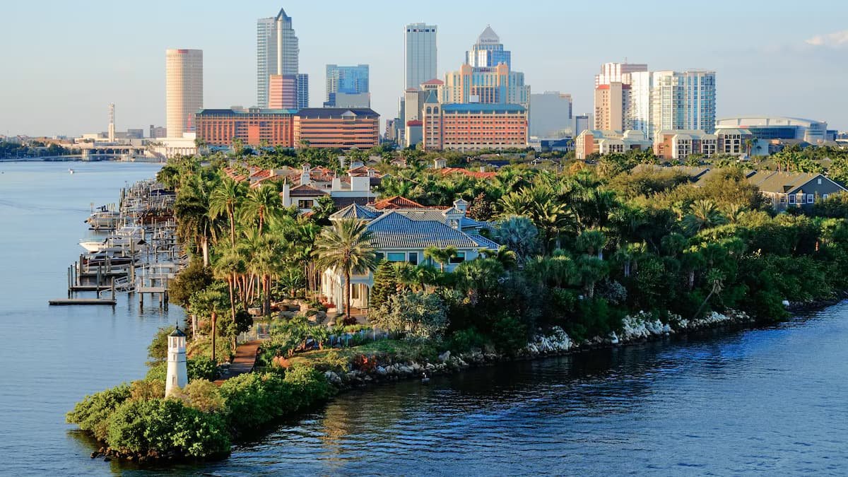 Sunlit modern Florida home exterior with tropical landscaping and large glass walls